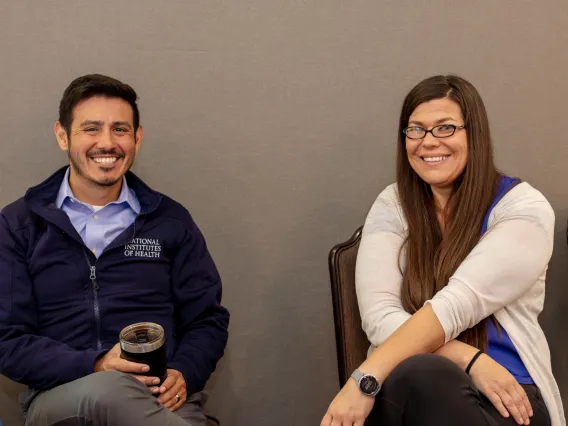 two sitting individuals smiling at camera