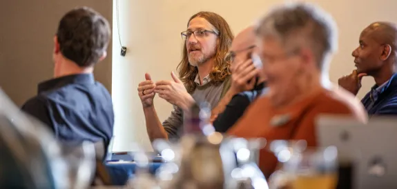 long-haired man talking at seminar