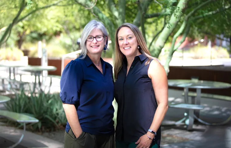 Two women in front of a palo verde